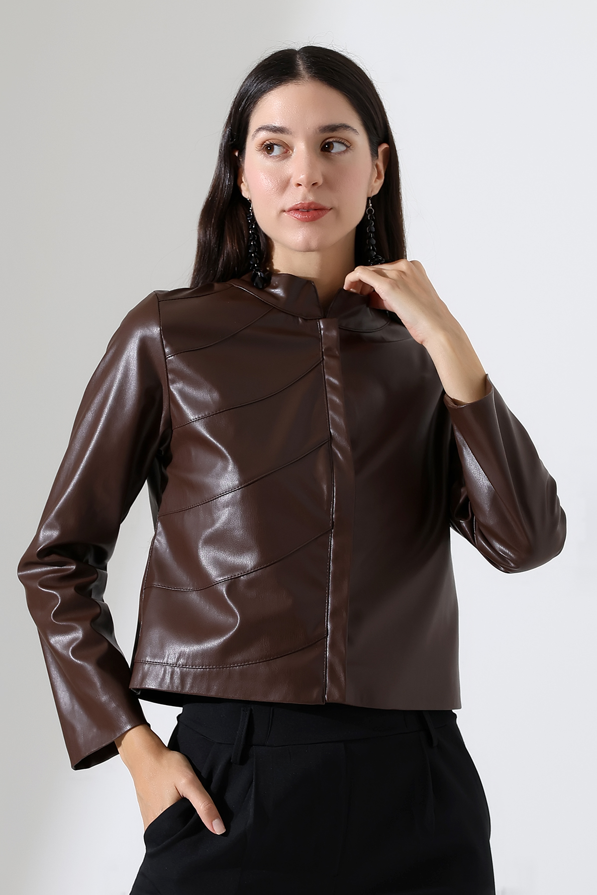 Model in garden wearing short tan leather jacket